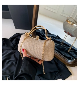 Close-up of champagne gold evening bag with glitter finish and diamond clasp