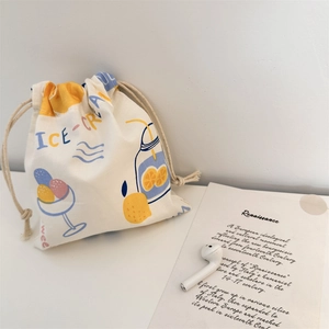 Detail of a canvas drawstring bag with ice cream print next to wireless earphones