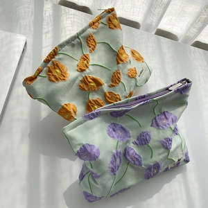 Detail of floral jacquard makeup bags featuring 3D textures and elegant zipper closure