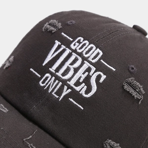 Detail of Good Vibes Only white embroidery and distressed holes on black cotton cap