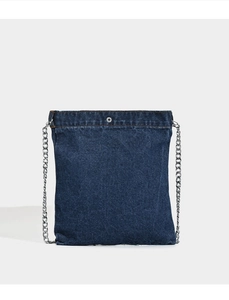 Detail of dark blue denim crossbody bag with silver metal chain strap and snap button
