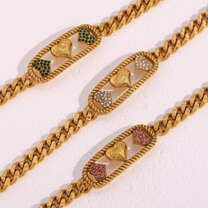 Détail de colliers en chaîne cubaine plaqués or 18 carats avec pendentifs cœur en cristal