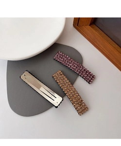 Close-up of elegant rhinestone hair clips and silver metal spring clip details
