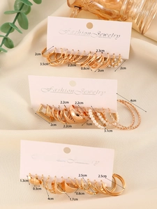 Detailed size guide for gold geometric earring set with pearls on satin background