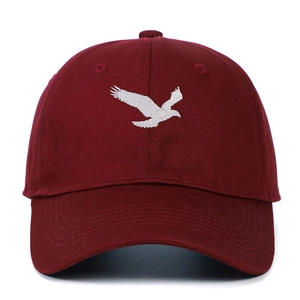 Détail de la broderie d'aigle blanc sur casquette de baseball en coton bordeaux