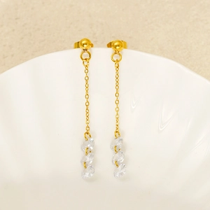 Boucles d'oreilles minimalistes en acier doré avec glands en zircone sur bol blanc
