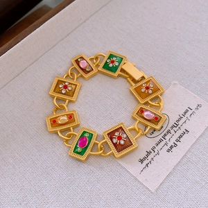 Macro shot of French vintage gold bracelet with colorful enamel and inlaid gemstones
