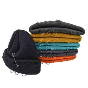 Distressed knit beanie with metal safety pin and rings, available in various colors