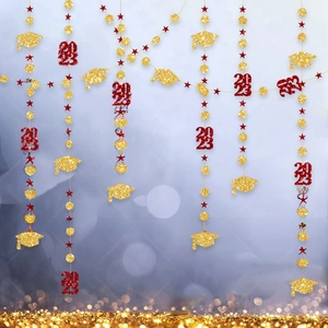 Close-up of sparkling gold 2023 graduation cap and red star hanging party decorations