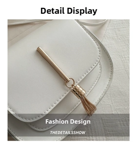 Close-up of white lychee pattern leather with gold metal chain tassel and stitching