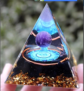 Detailed view of resin energy pyramid with purple amethyst sphere and copper coil