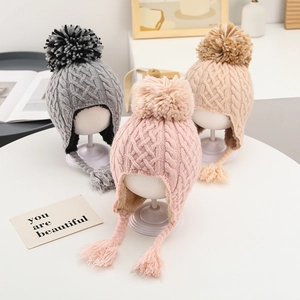 Detailed knit texture and thick fleece lining of winter earflap hats with pom-poms
