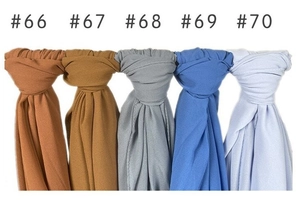 Macro detail of solid color chiffon shawls in caramel, yellow, gray, blue and violet shades