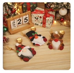 Three gnome-shaped Christmas cutlery holders set on a festive table with holiday decor