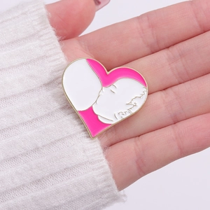 Pink heart-shaped enamel brooch pin showing mother nursing baby with golden metal edges