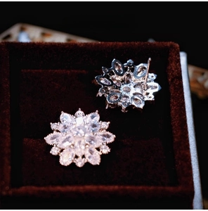 Macro detail of snowflake zircon earrings on velvet box with brilliant sparkle