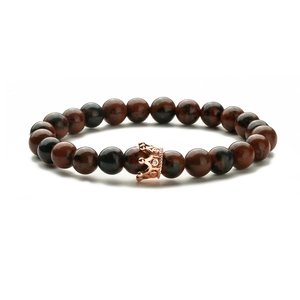 Achatstein-Armband mit roségoldenem Kronenanhänger auf weißem Hintergrund