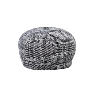 Detail of black and white plaid tweed newsboy cap with octagonal panels and top button