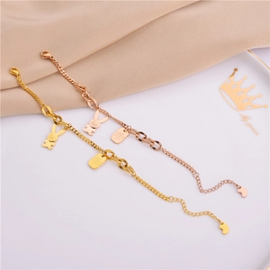Detail of rose gold bunny pendant bracelets displayed on elegant silk fabric