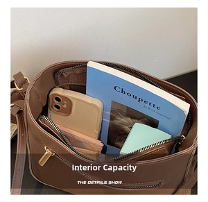 Detail view showing the spacious interior compartments of the brown crossbody bag