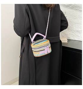 Dettaglio di una mini borsa a secchiello intrecciata colorata con tracolla a catena