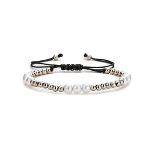 Adjustable woven bracelet with white pearls and silver metal beads on a white background