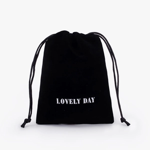 Detail of black velvet drawstring pouch with Lovely Day print for jewelry storage