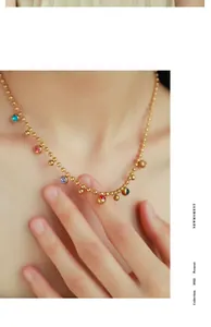 Detail view of 18k gold plated bead chain necklace with colorful round enamel pendants