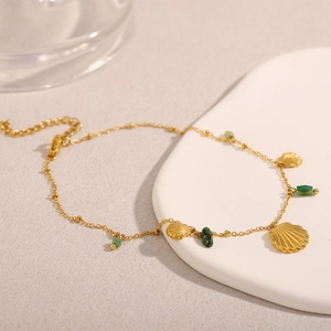 Détail de la chevillère plaquée or 18K avec pendentifs coquillages et perles vertes