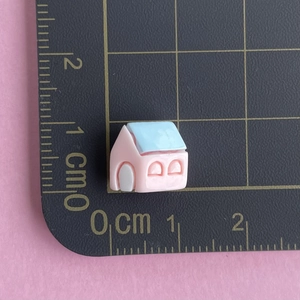 Miniature pink and blue resin house charm shown with scale ruler for 1cm size reference