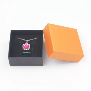 Close-up of black and orange jewelry gift box with gemstone necklace and ring set