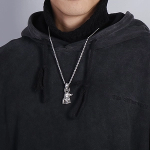 Detailed close-up of silver Anubis pendant with twist chain worn on a black hoodie