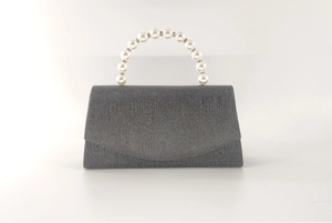 Detail of black glitter evening bag featuring a faux pearl circular handle and shimmering finish