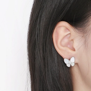 Close-up of elegant butterfly stud earrings with white mother of pearl and diamond detail