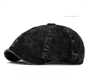 Detailed texture of black corduroy newsboy cap featuring classic eight-panel crown design