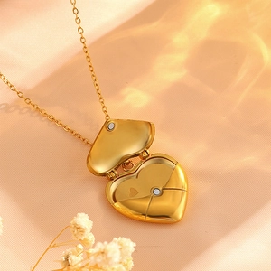 Detailed macro view of an openable heart-shaped 18k gold-plated locket with magnetic closure