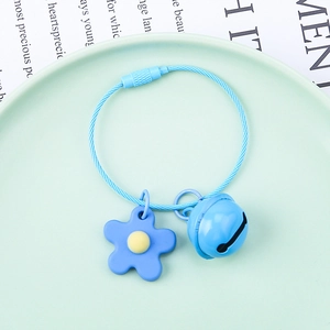 Detail of blue flower keychain with matching bell and screw lock cable ring on a tray