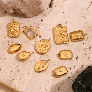 Flat lay of 18K gold plated charms with rose engraving and cubic zirconia details
