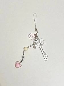Macro detail of transparent acrylic key charm and pink heart beads on mobile phone strap