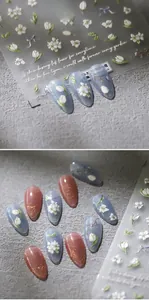 Macro view of 5D embossed floral nail stickers with tulips and daisies on nail tips