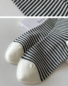 Makrotextur gestreifter Baumwollsocken mit Bärenstickerei und weißem Zehendetail