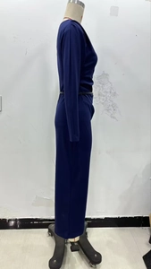 Detail view of the elegant pleated waist design on a dark blue long-sleeved dress