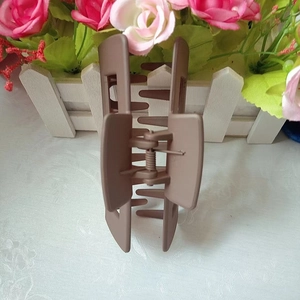Detail showing the internal spring mechanism of an open 10.5cm matte coffee hair claw clip