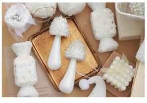 Detailed view of white glitter mushroom and star candy Christmas ornaments on a tray