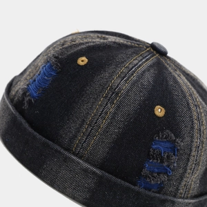 Macro shot of distressed denim docker hat with vintage wash and contrast embroidery