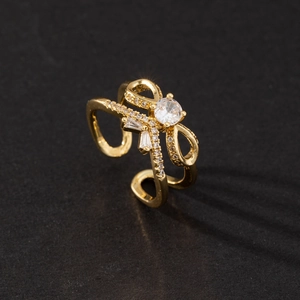 Macro view of gold bow-shaped ring with zircon stones and adjustable double-layered band