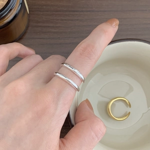 Close-up of minimalist 925 sterling silver layered rings worn on index finger