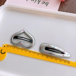 Detailed size view of silver leather heart and teardrop hair clips with colorful dots
