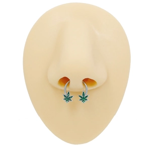 Silver horseshoe septum ring with green maple leaf charm on a silicone nose model