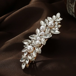 Elegant gold leaf hair clip with marquise rhinestones and pearls on satin backdrop